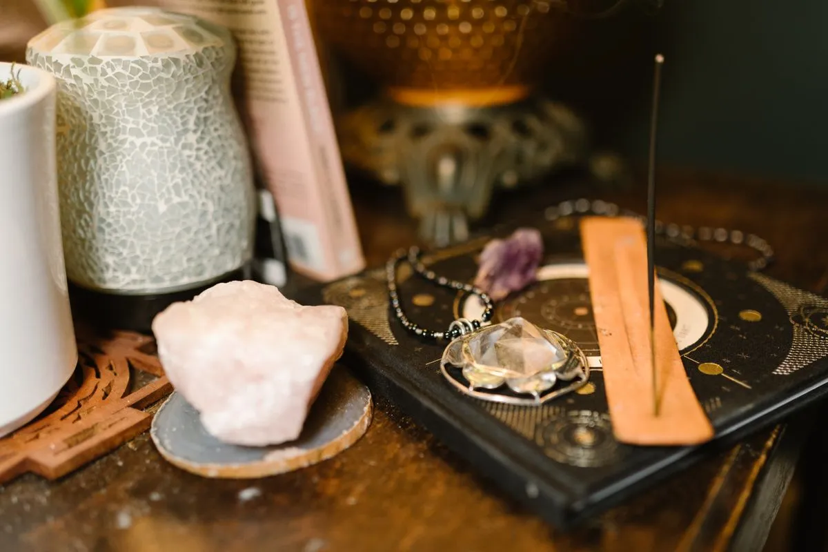 Astrology items including incense and crystals arranged on a wooden surface