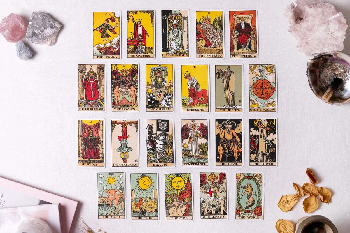 A full tarot spread surrounded by crystals and dried flowers