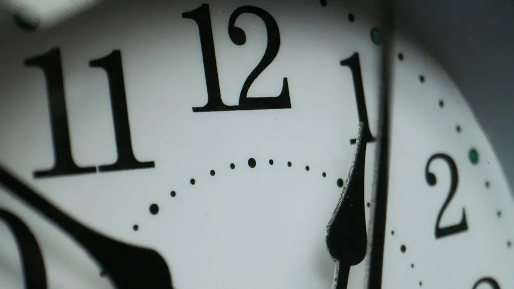 Macro close-up of a clock face showing its numbers and minute markers