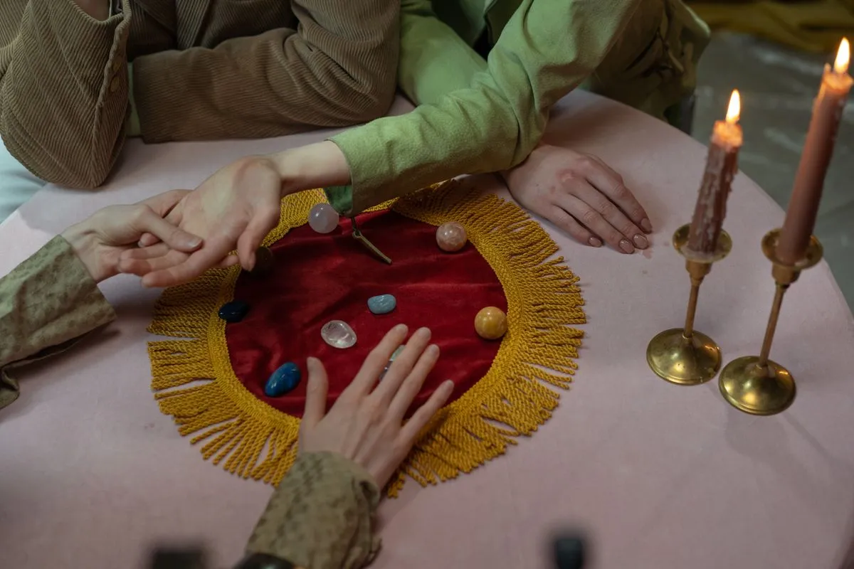 A palm reading session with candles and mystical objects on the table