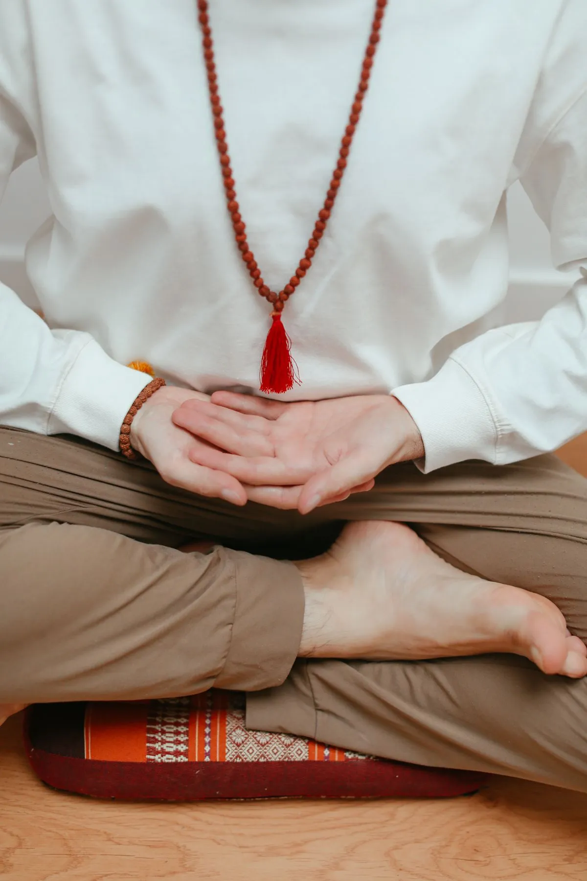 A person meditating peacefully with mala beads in hand